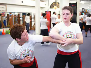 Instructor Grace demonstrates a 'Counter Arm Grab' technique.