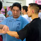 A Wing Chun instructor teaches a student a movement from Siu Nim Tau
